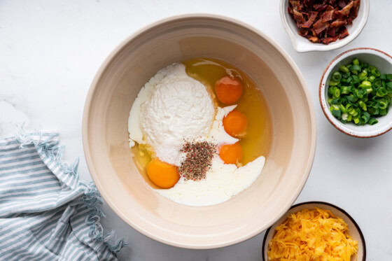 Egg, flour, milk, and spices in a large mixing bowl.