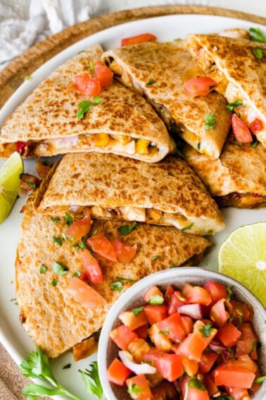 Healthy chicken quesadilla on a plate with a side bowl of pico de gallo.