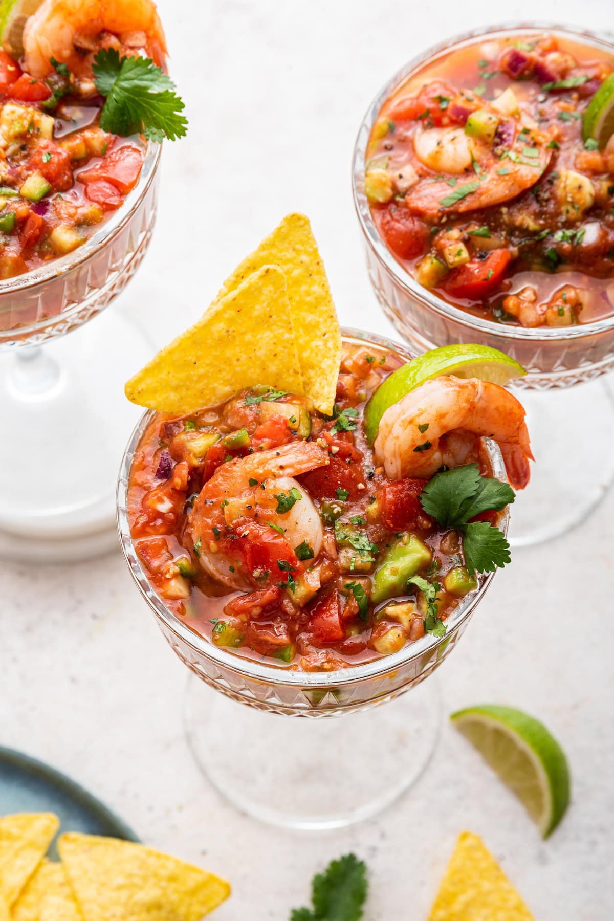 A mexican shrimp cocktail in a small glass with a tortilla chip.