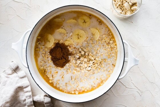 A large pot of oats, bananas, cinnamon, and milk.