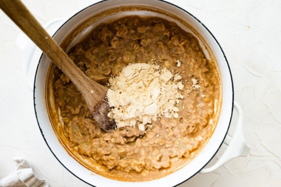 A large pot of oats with a scoop of protein powder in the center.