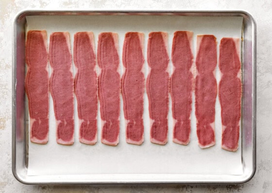 Raw turkey bacon on a baking tray.