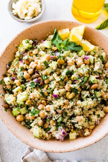 A salad inspired by Jennifer Aniston in a large bowl with quinoa, chickpeas, fresh herbs, and vegetables.