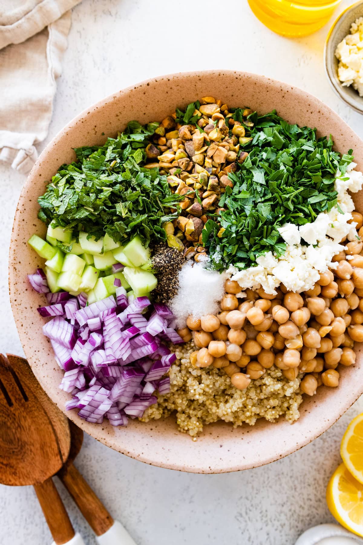 A salad inspired by Jennifer Aniston in a large bowl with quinoa, chickpeas, fresh herbs, and vegetables.