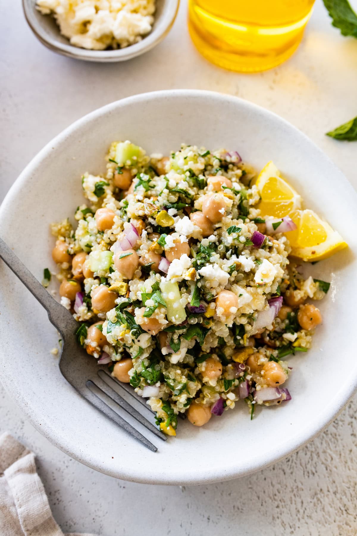 A salad inspired by Jennifer Aniston in a small bowl with quinoa, chickpeas, fresh herbs, and vegetables.