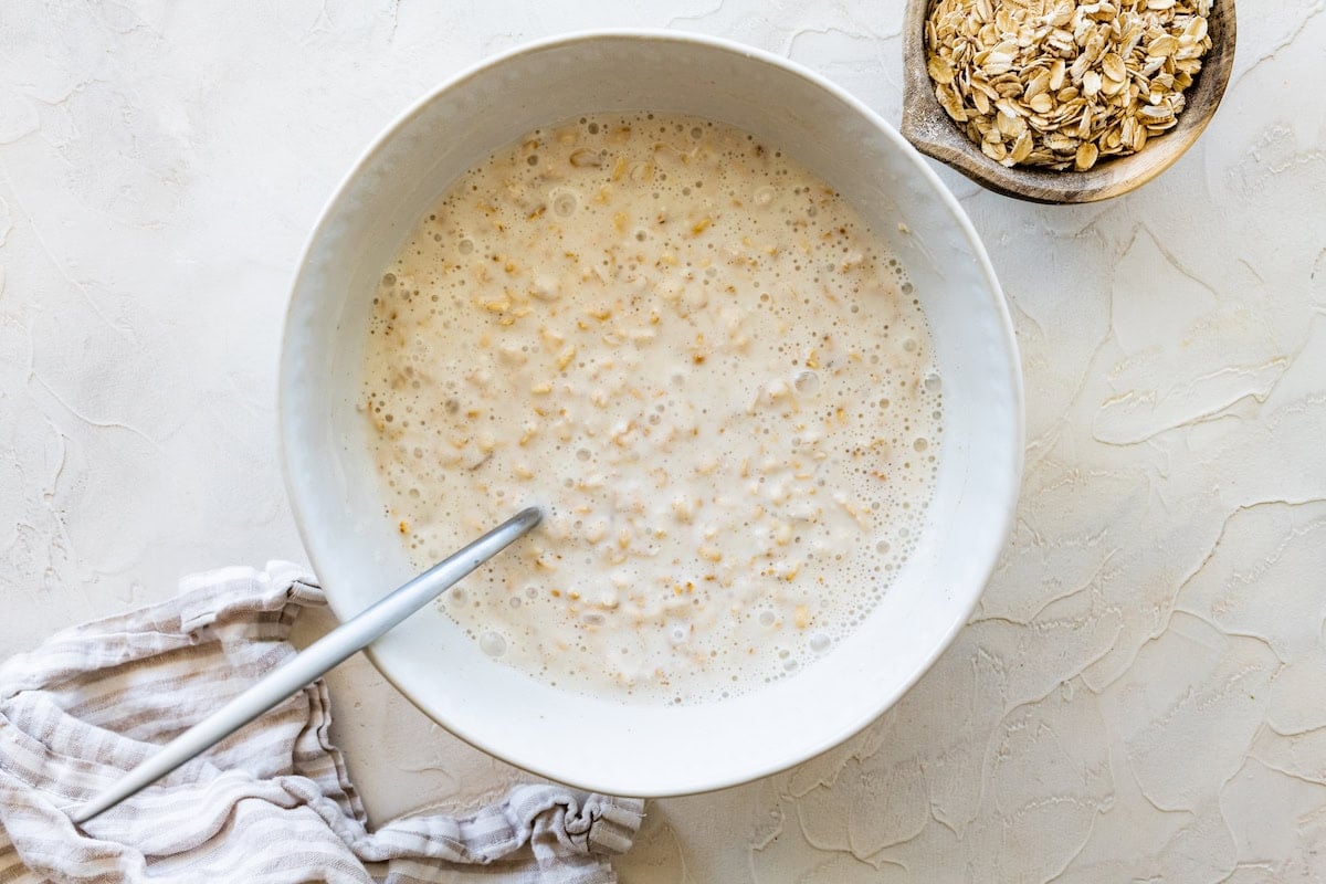 Rolled oats soaking in a large bowl of milk.