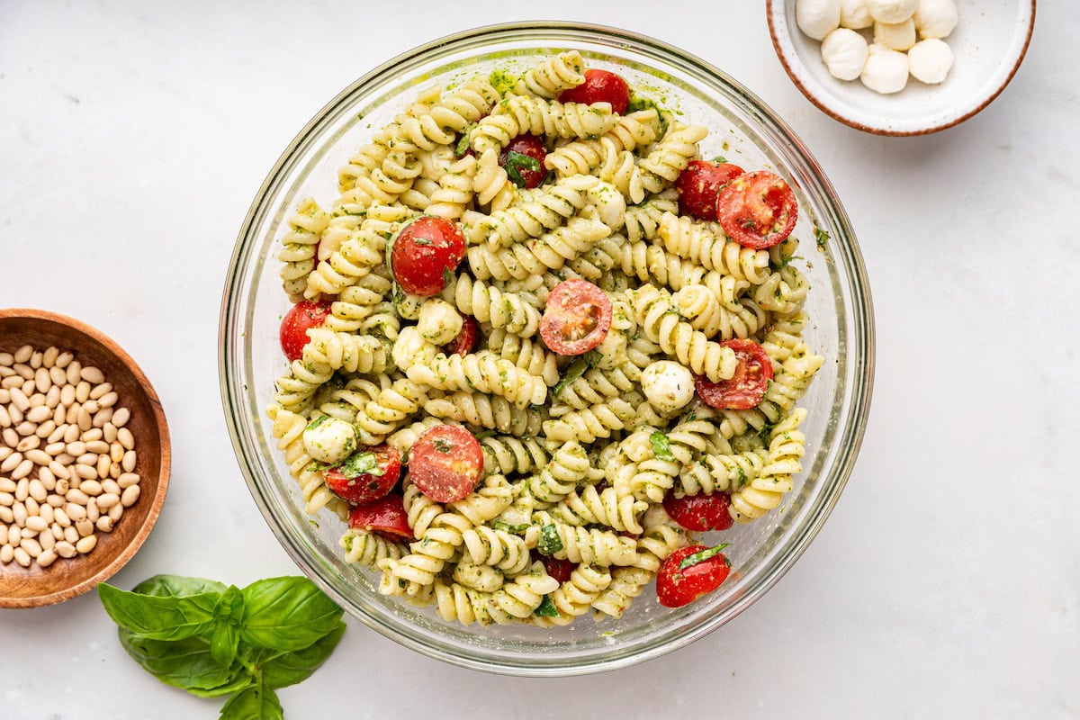 Pesto pasta salad in a large glass bowl.