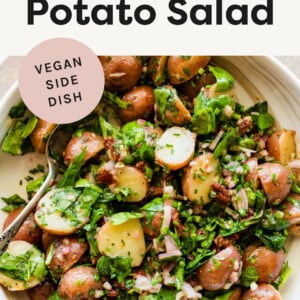 No Mayo Potato Salad with spinach and a shallot vinaigrette in a bowl.