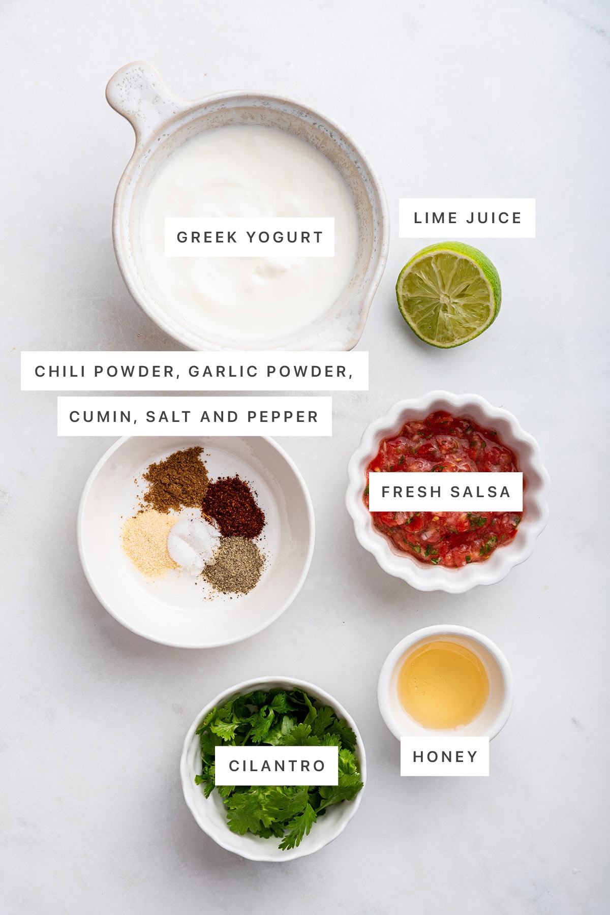 Ingredients measured out to make Southwest Dressing: Greek yogurt, lime juice, chili powder, garlic powder, cumin, salt and pepper, fresh salsa, cilantro and honey.