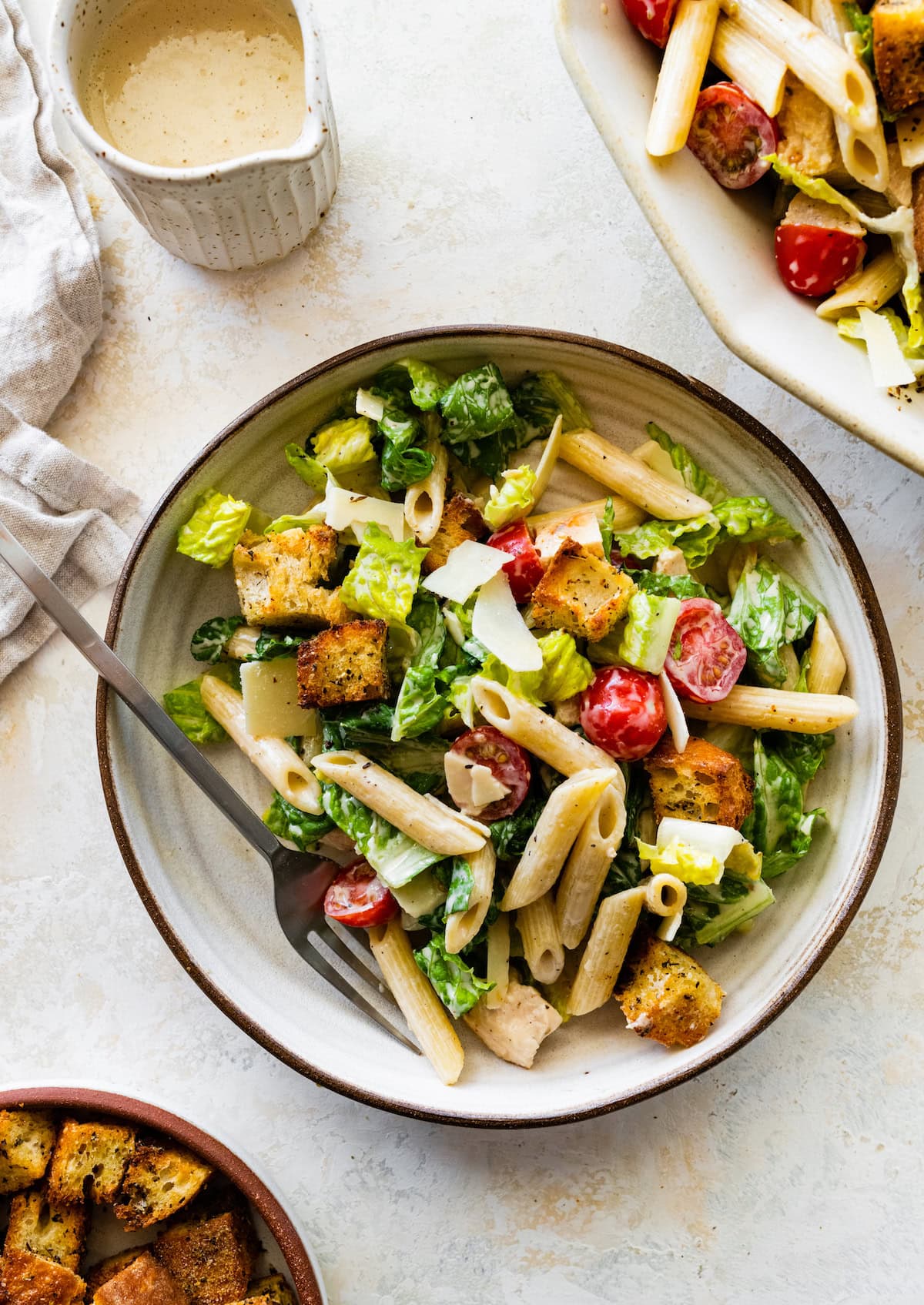 A serving of chicken caesar pasta salad on a plate.