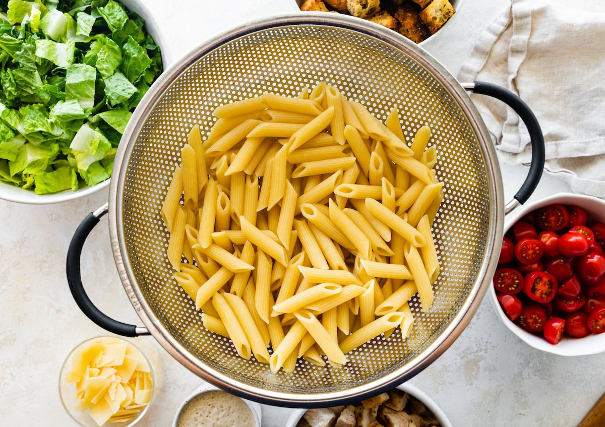 Pasta noodles in a strainer.