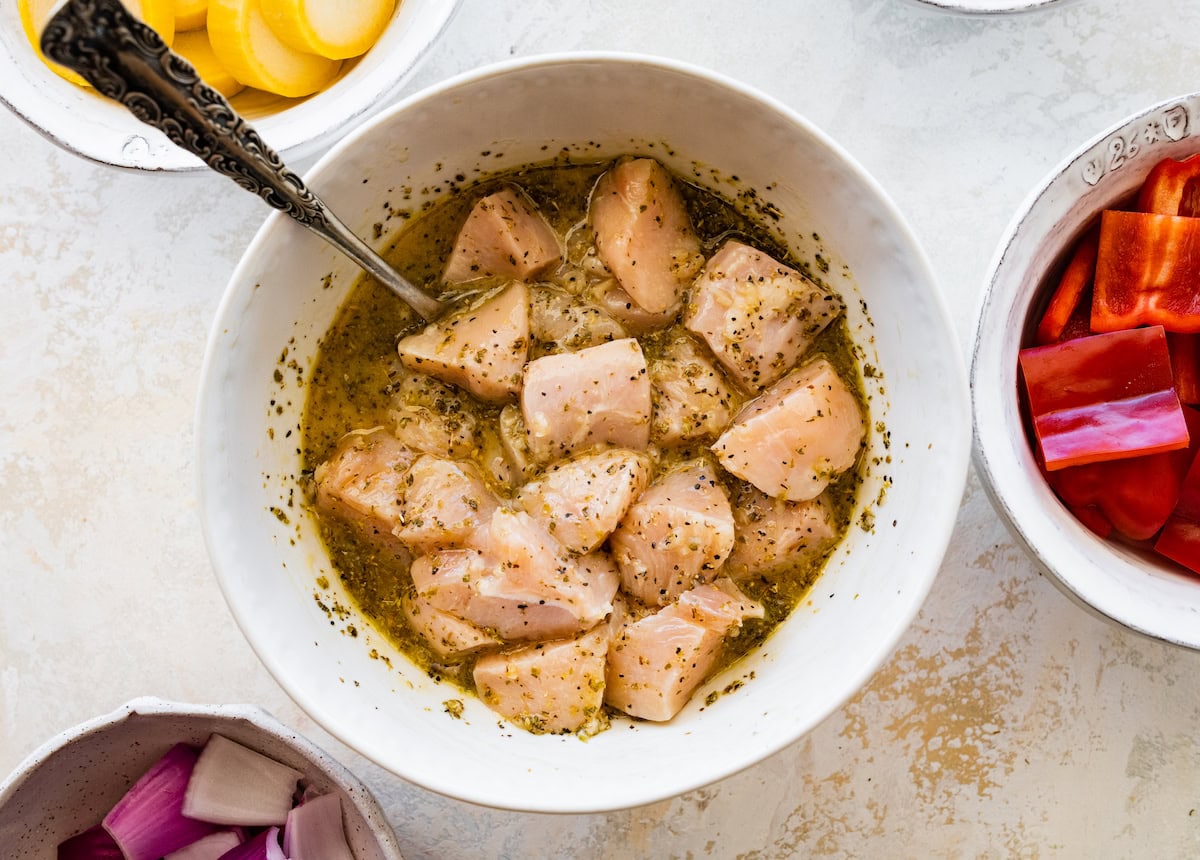 Raw chicken in a bowl of marinade.