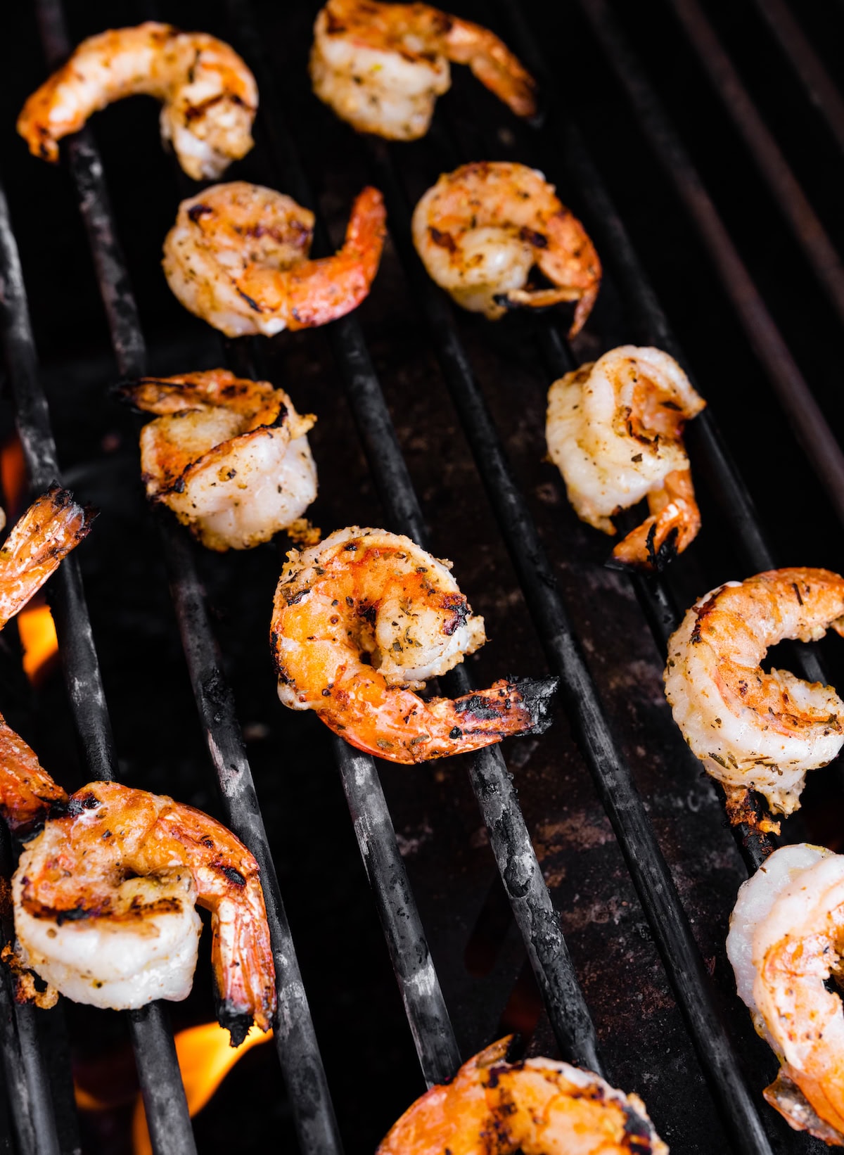 Multiple pieces of shrimp being cooked on a grill.