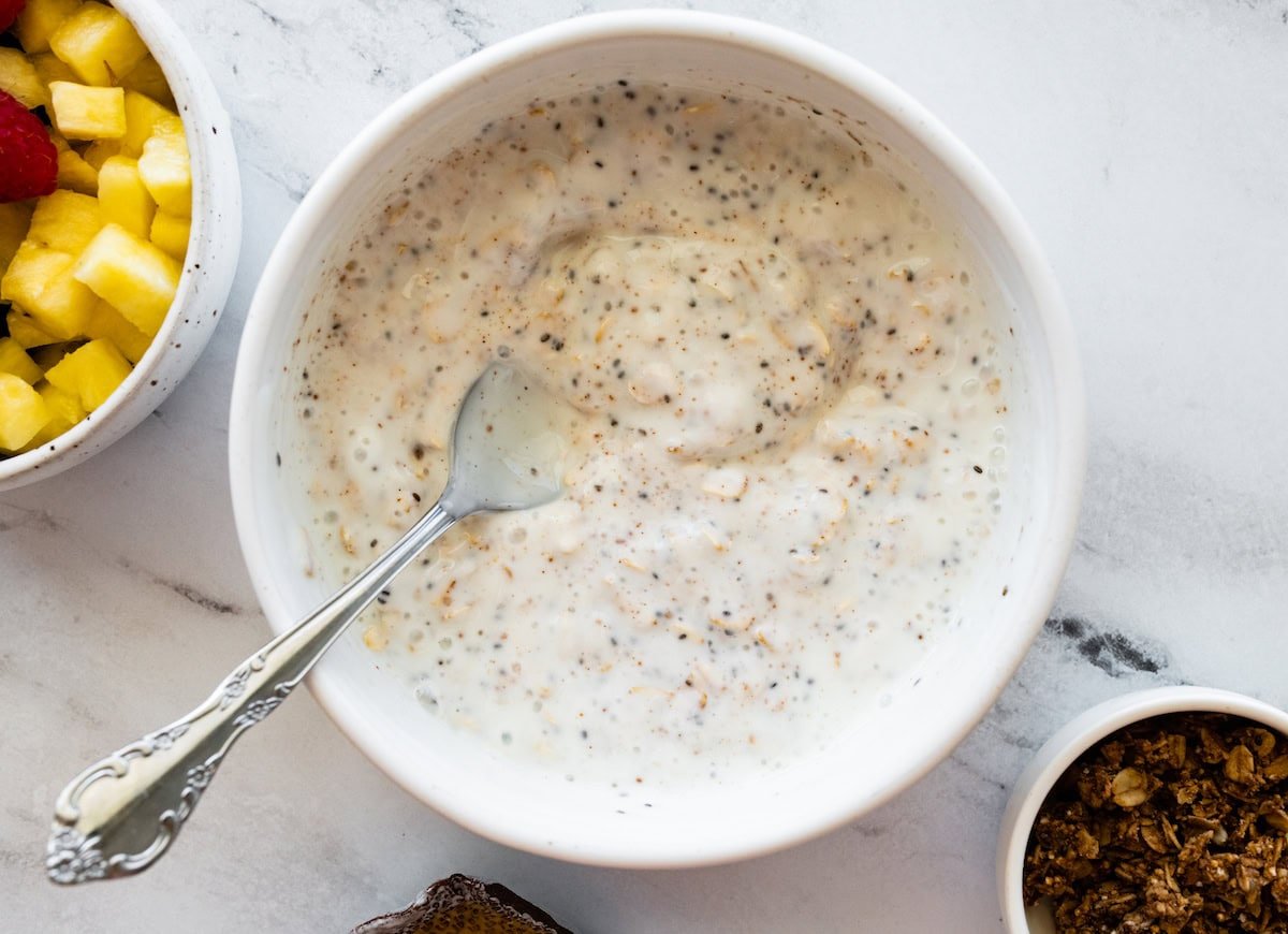 A large bowl of milk, rolled oats, chia seeds, and cinnamon.