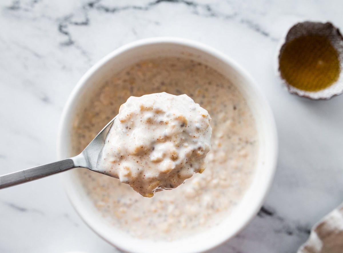 A spoonful of kefir overnight oats over a large bowl.