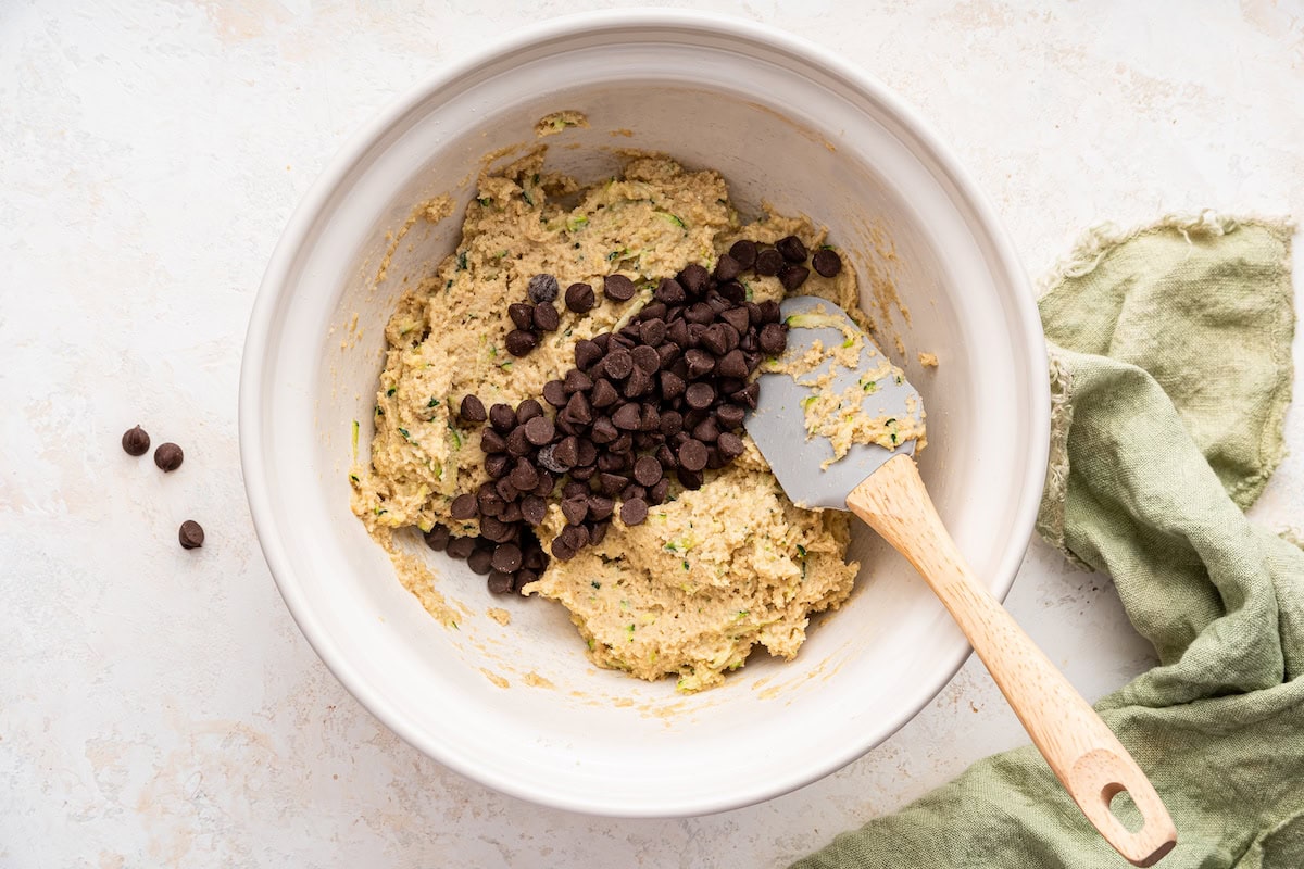 Wet and dry ingredients combined in a large mixing bowl with chocolate chips added.
