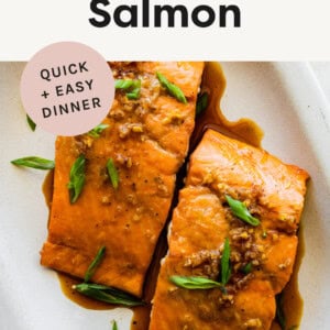 Two pieces of Maple Glazed Salmon on a platter and garnished with green onions.