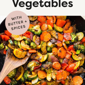 Sautéed Vegetables in a skillet with a wood spatula.