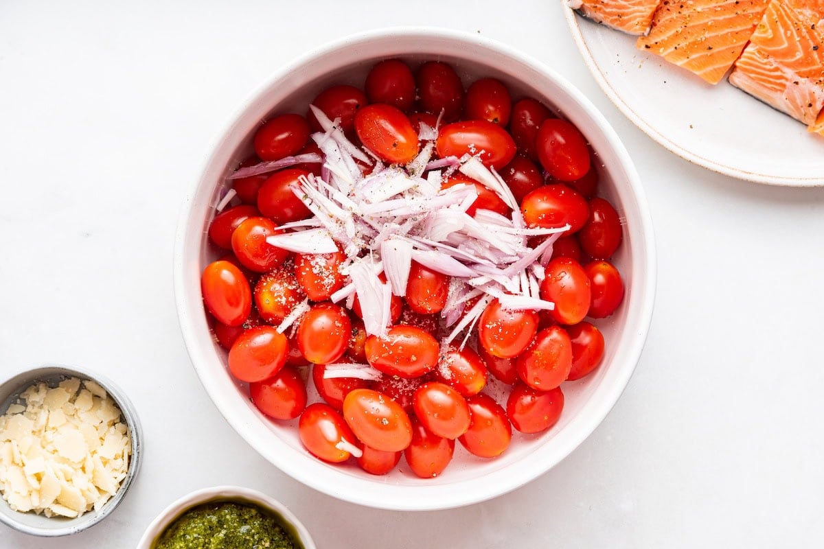 A bowl of cherry tomatoes and chopped shallots.