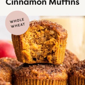 Two Healthy Apple Cinnamon Muffins stacked, the top one has a bite taken out of it.