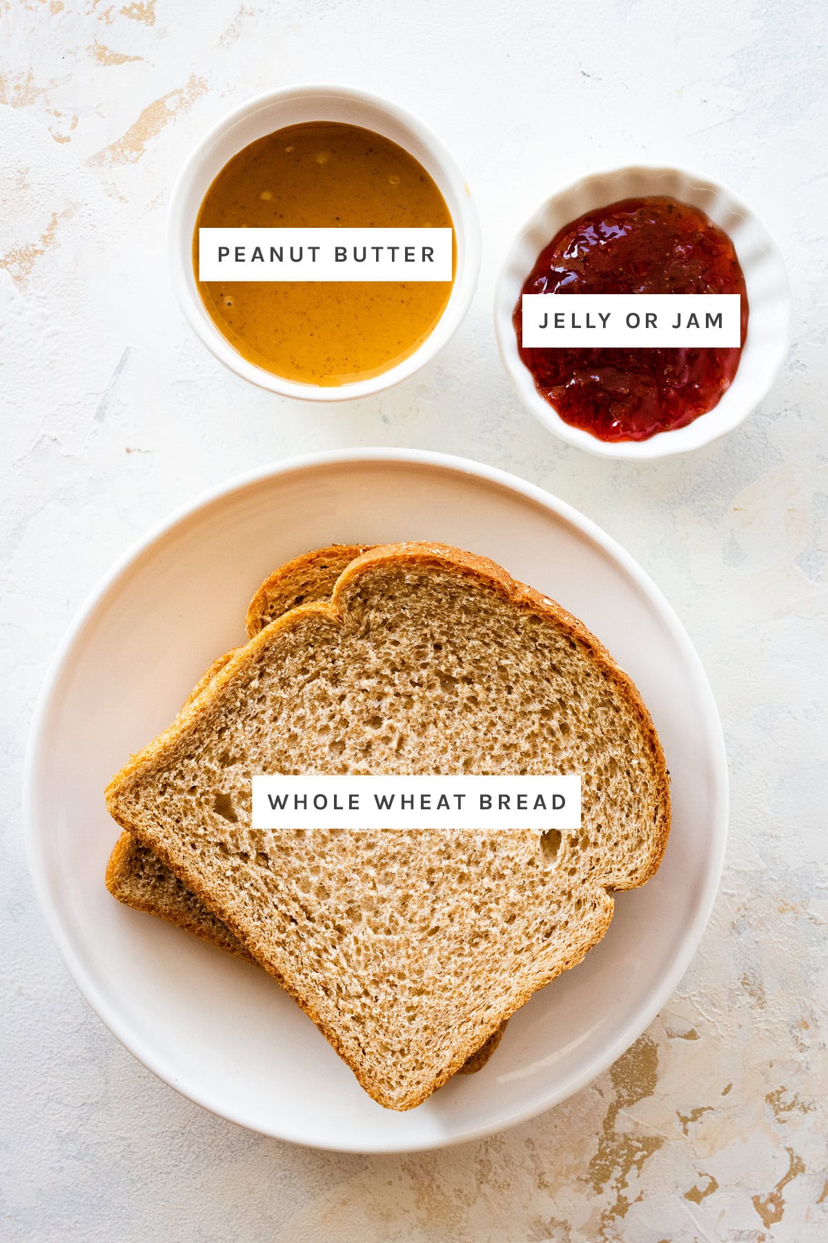 Ingredients measured out to make Homemade Uncrustables: peanut butter, jelly and whole wheat bread.