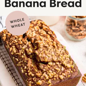 Loaf of Pumpkin Banana Bread topped with nuts on a cooling rack.