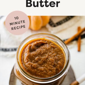 Pumpkin Butter in a jar next to a spoon, cinnamon sticks and a mini pumpkin.