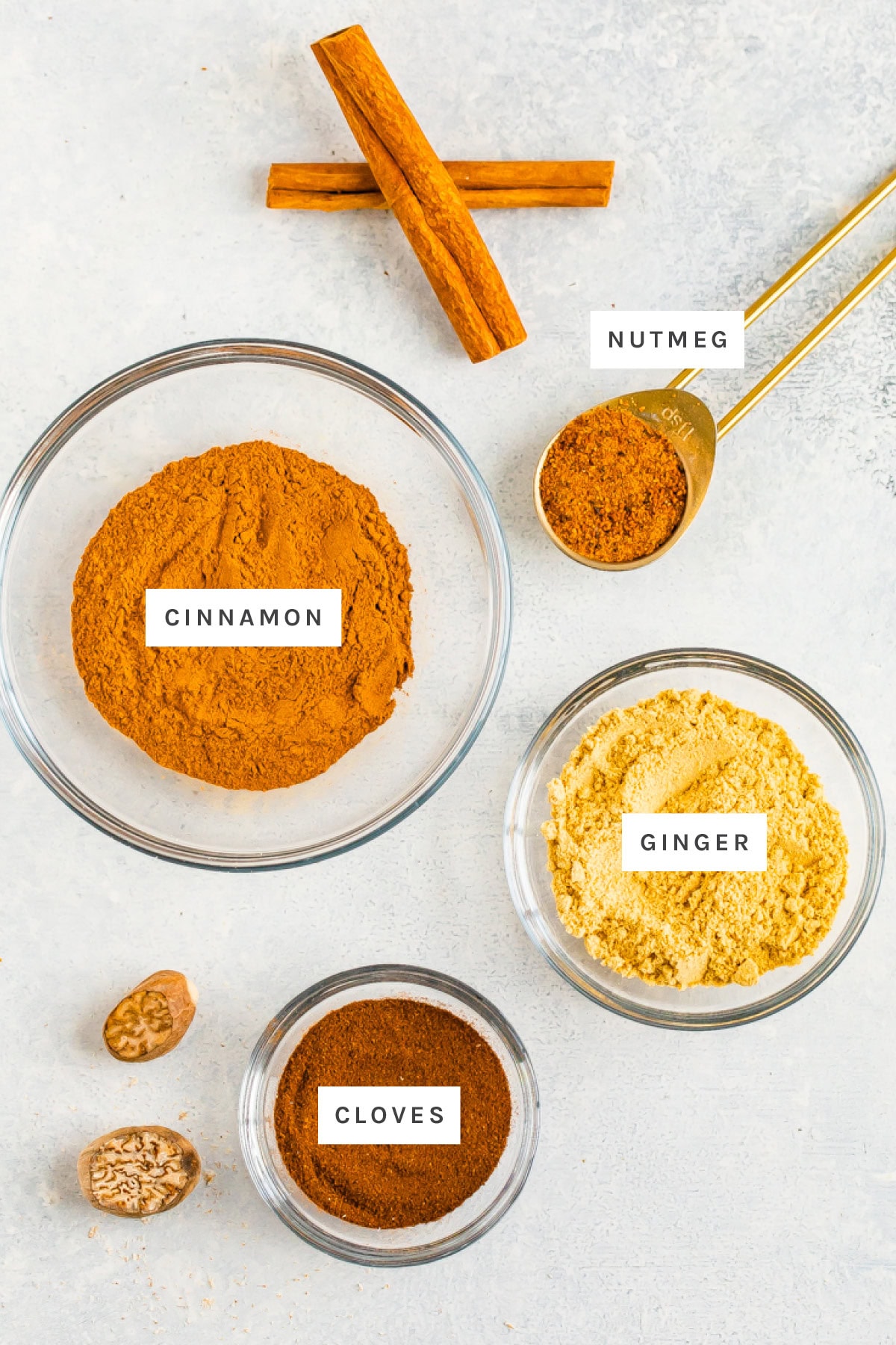 Ingredients measured out to make Pumpkin Pie Spice: cinnamon, nutmeg, ginger and cloves.