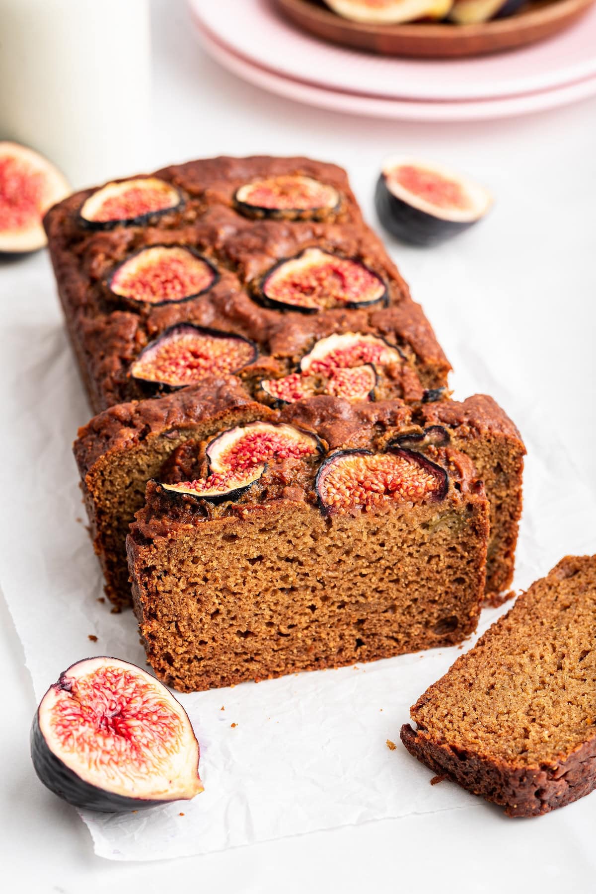 A loaf of fig bread topped with fig slices cut into multiple slices.