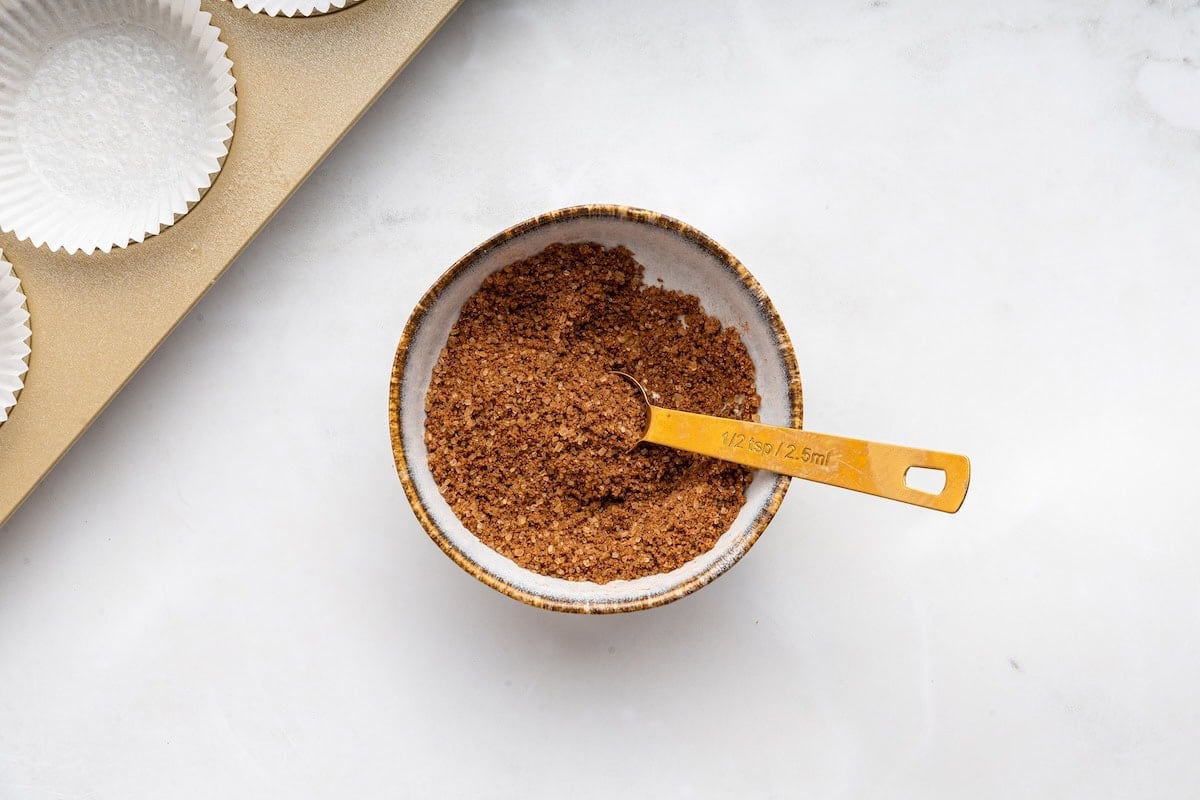A sugar and cinnamon mix in a small bowl with a 1/2 teaspoon inside.
