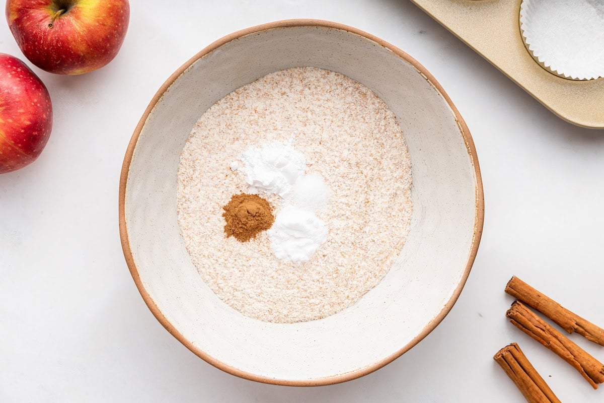 All the dry ingredients used for apple muffins in a large mixing bowl.