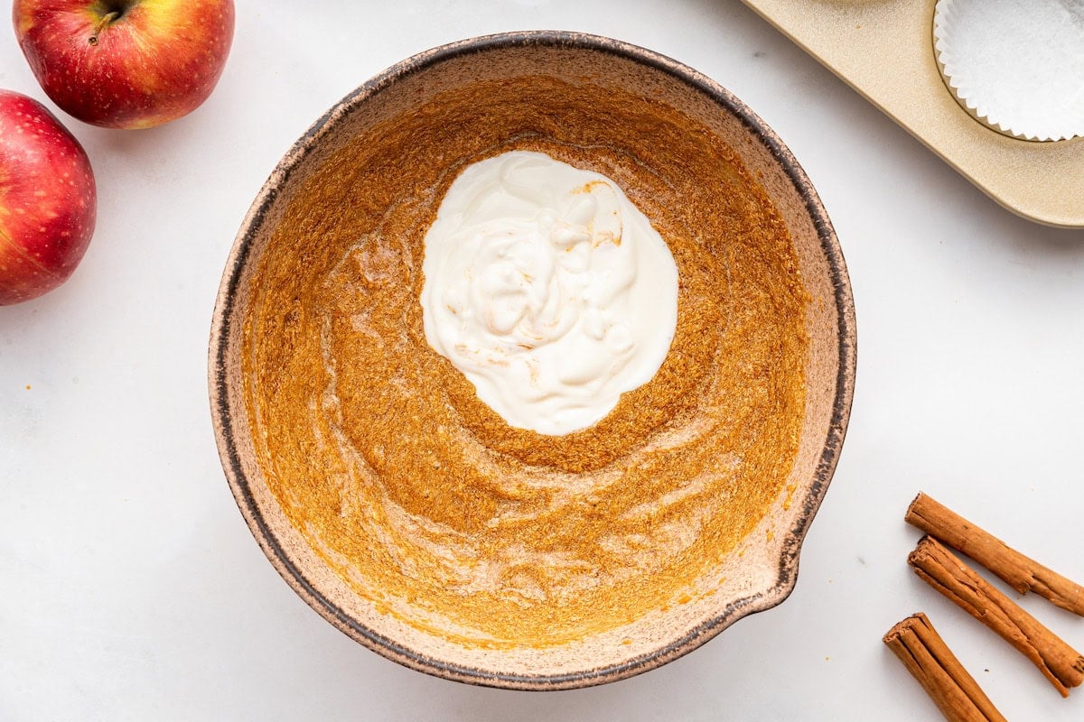 All the wet ingredients used for apple muffins in a large mixing bowl.