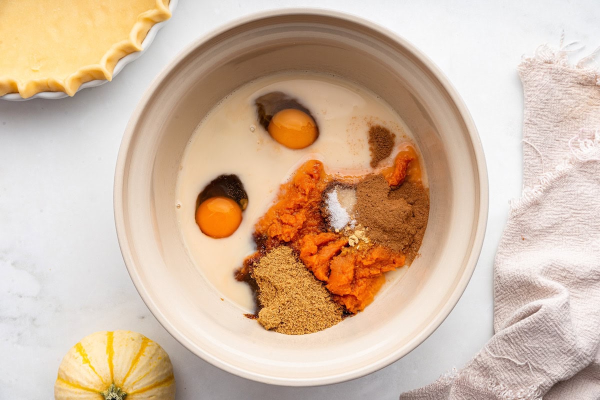 A large mixing bowl of ingredients used for a pumpkin pie.