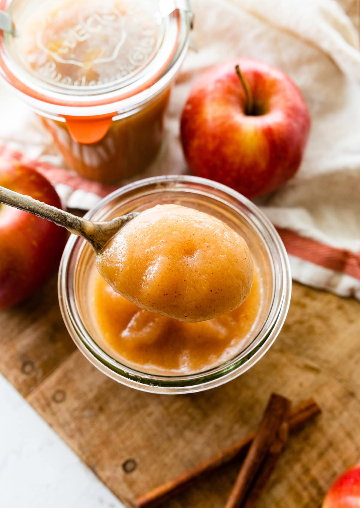 A spoonful of homemade applesauce over a mason jar of the applesauce.