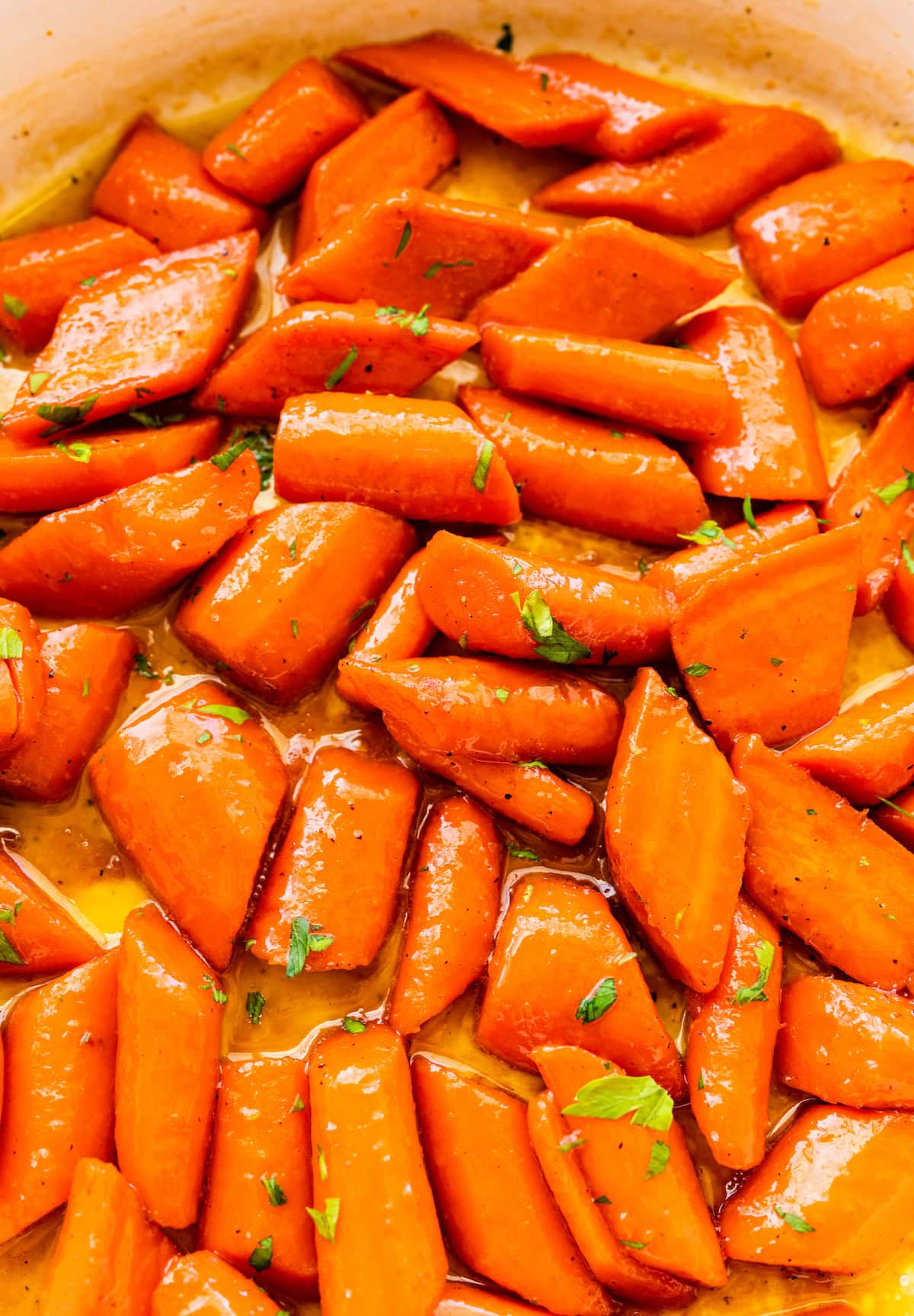 Glazed carrots cooked in a pan and topped with fresh thyme.