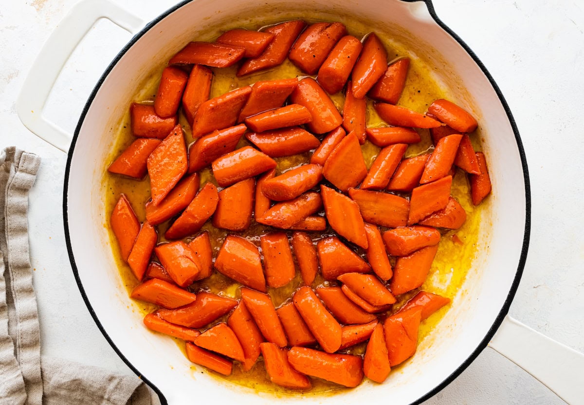 Glazed carrots cooked in a large pot.