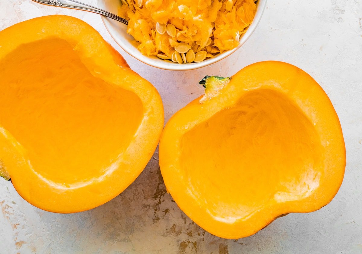 A small pumpkin split in half with the seeds and pulp of the pumpkin taken out.