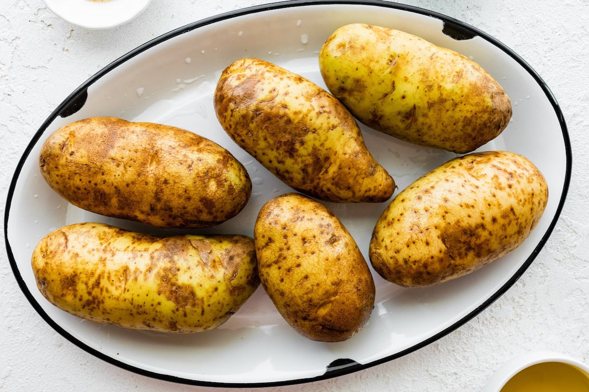 Six large russet potatoes in a large pot.