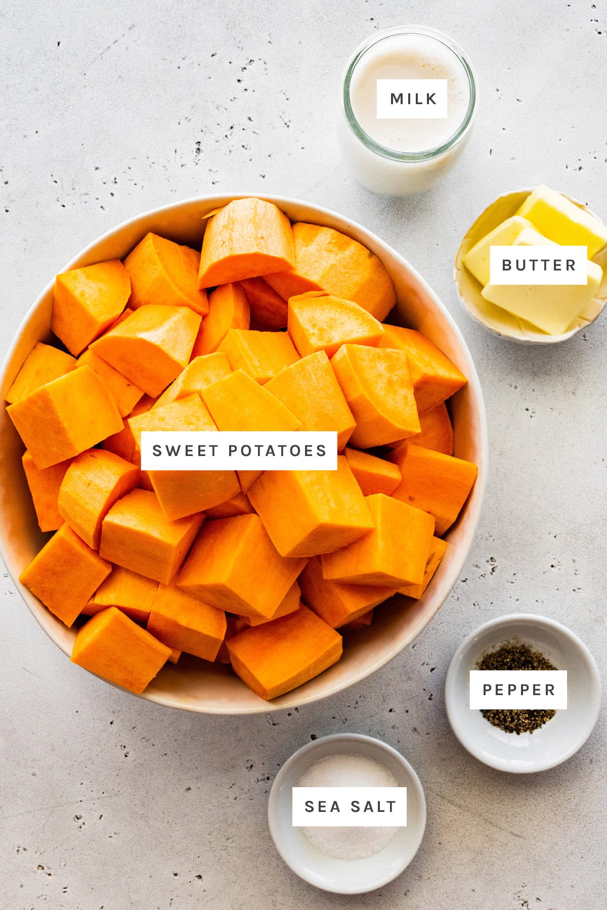 Ingredients measured out to make Mashed Sweet Potatoes: milk, butter, sweet potatoes, sea salt and pepper.