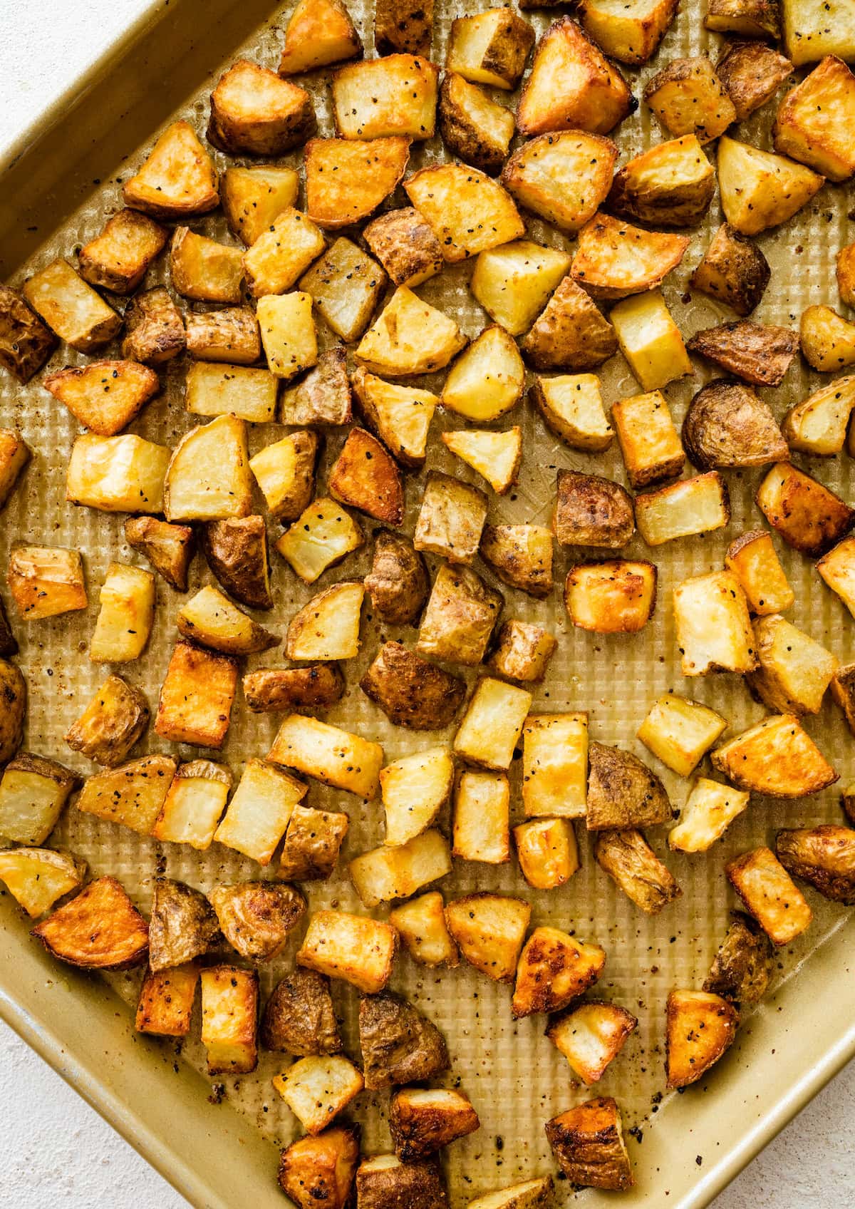 Roasted seasoned potatoes on a baking tray.
