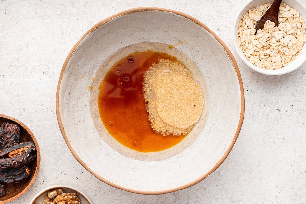 The wet ingredients for the oatmeal date cookies mixed together in a ceramic bowl.
