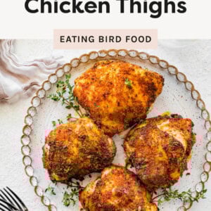 Air Fryer Chicken Thighs on a plate garnished with fresh herbs.