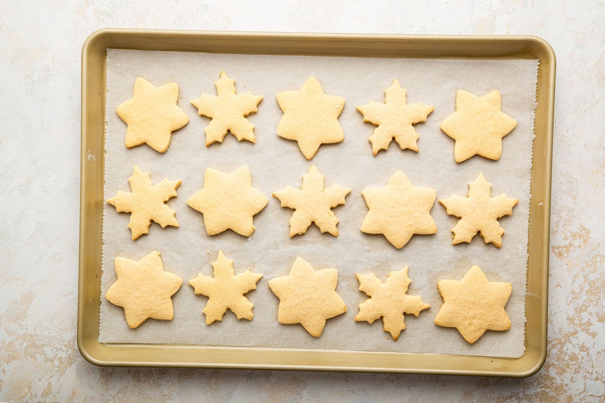 Gluten free sugar cookies on a baking tray after being baked in the oven.