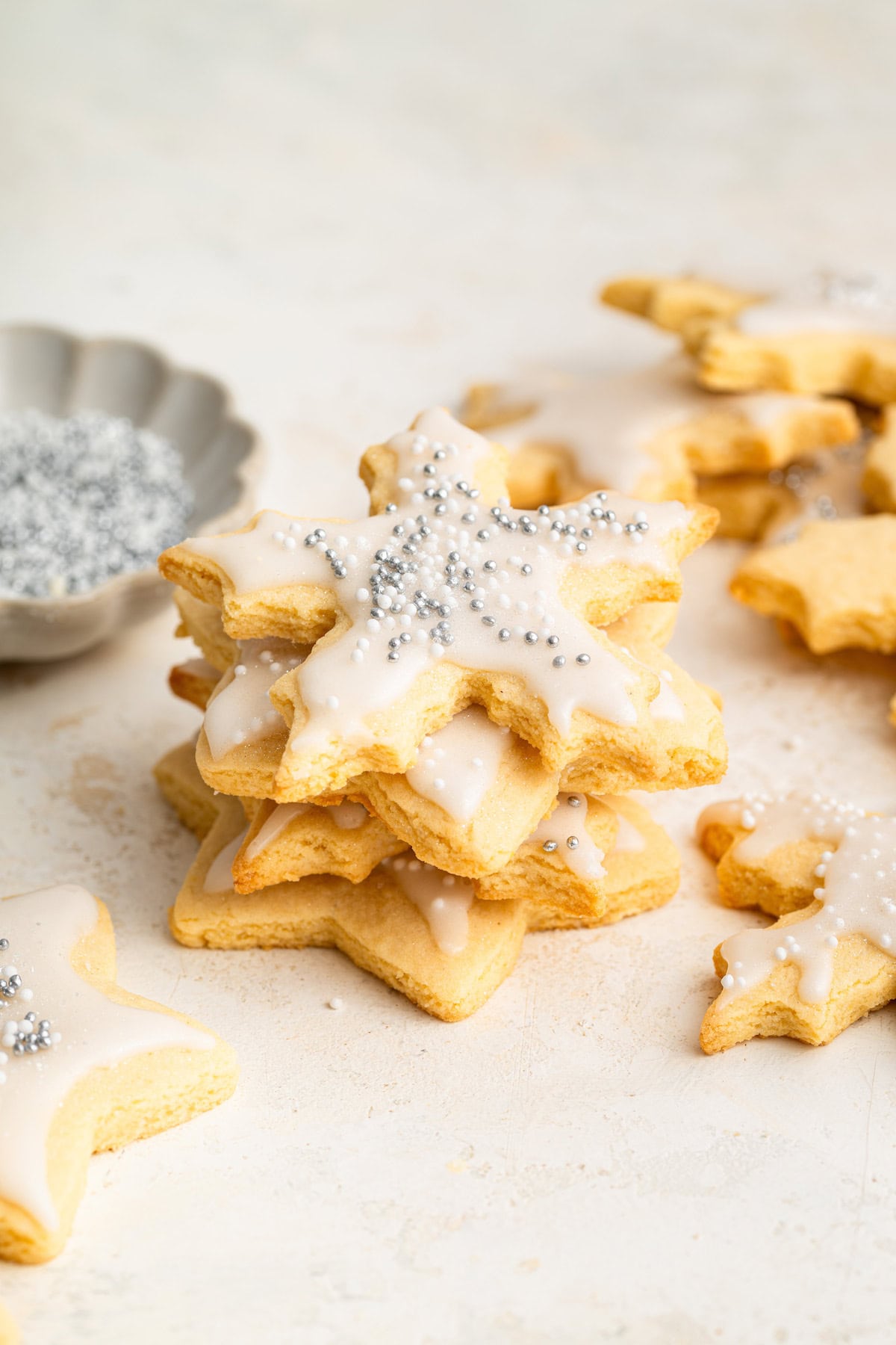 Gluten free sugar cookies decorated with icing stacked on one another.