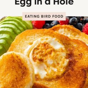 Egg in a Hole toast on a plate with avocado and berries.
