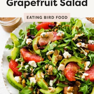 Avocado Grapefruit Salad on a plate topped with nuts, cheese and balsamic dressing.