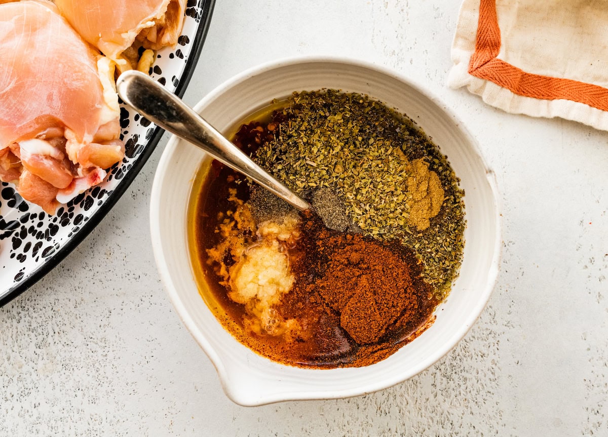 The chipotle chicken marinade in a small white bowl with a silver spoon.