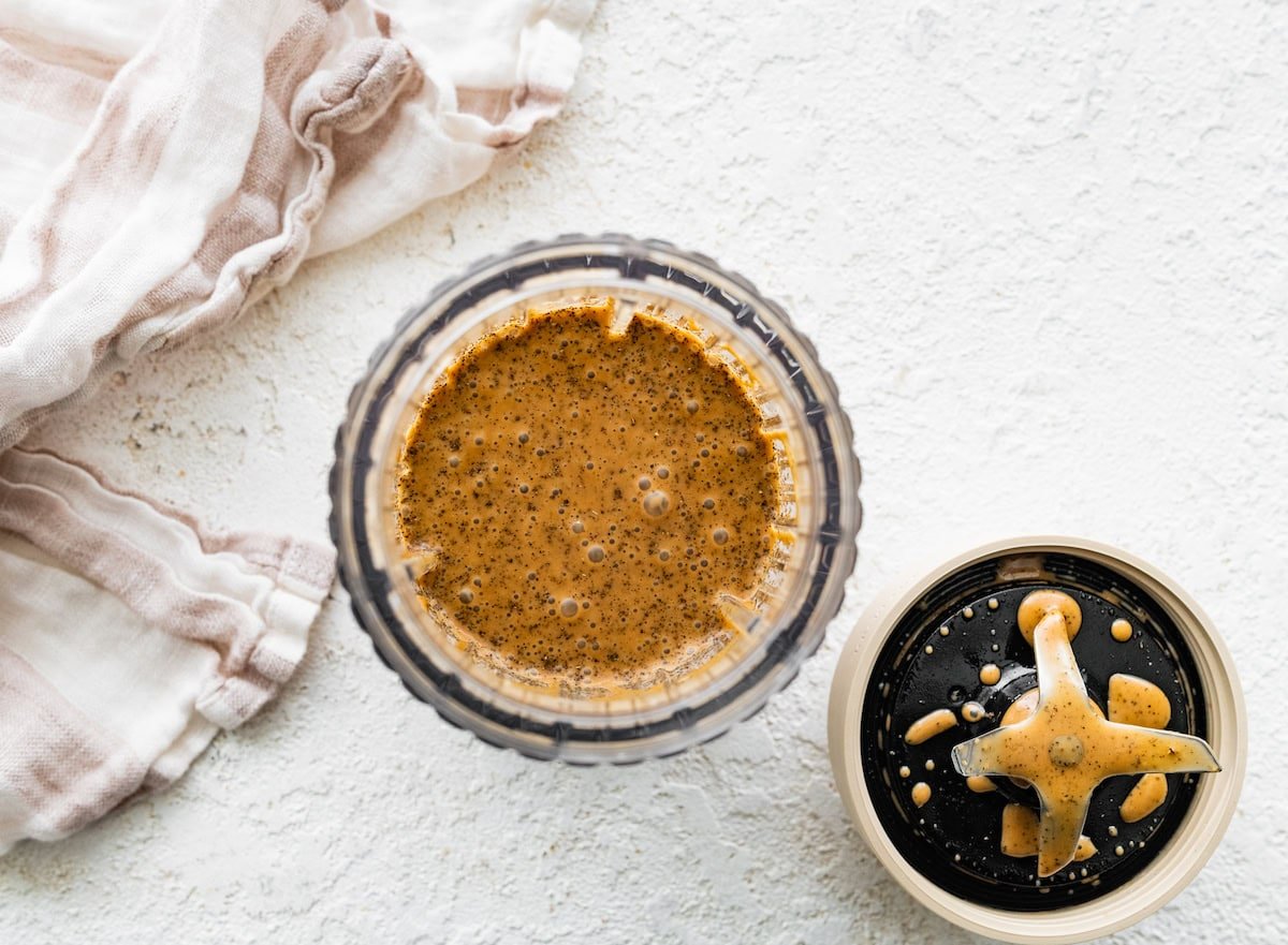A balsamic dressing with dried herbs, balsamic vinegar, oil, and more in a blender.