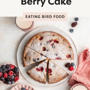 An overhead photo of berry cake cut up on a plate with berries on top.