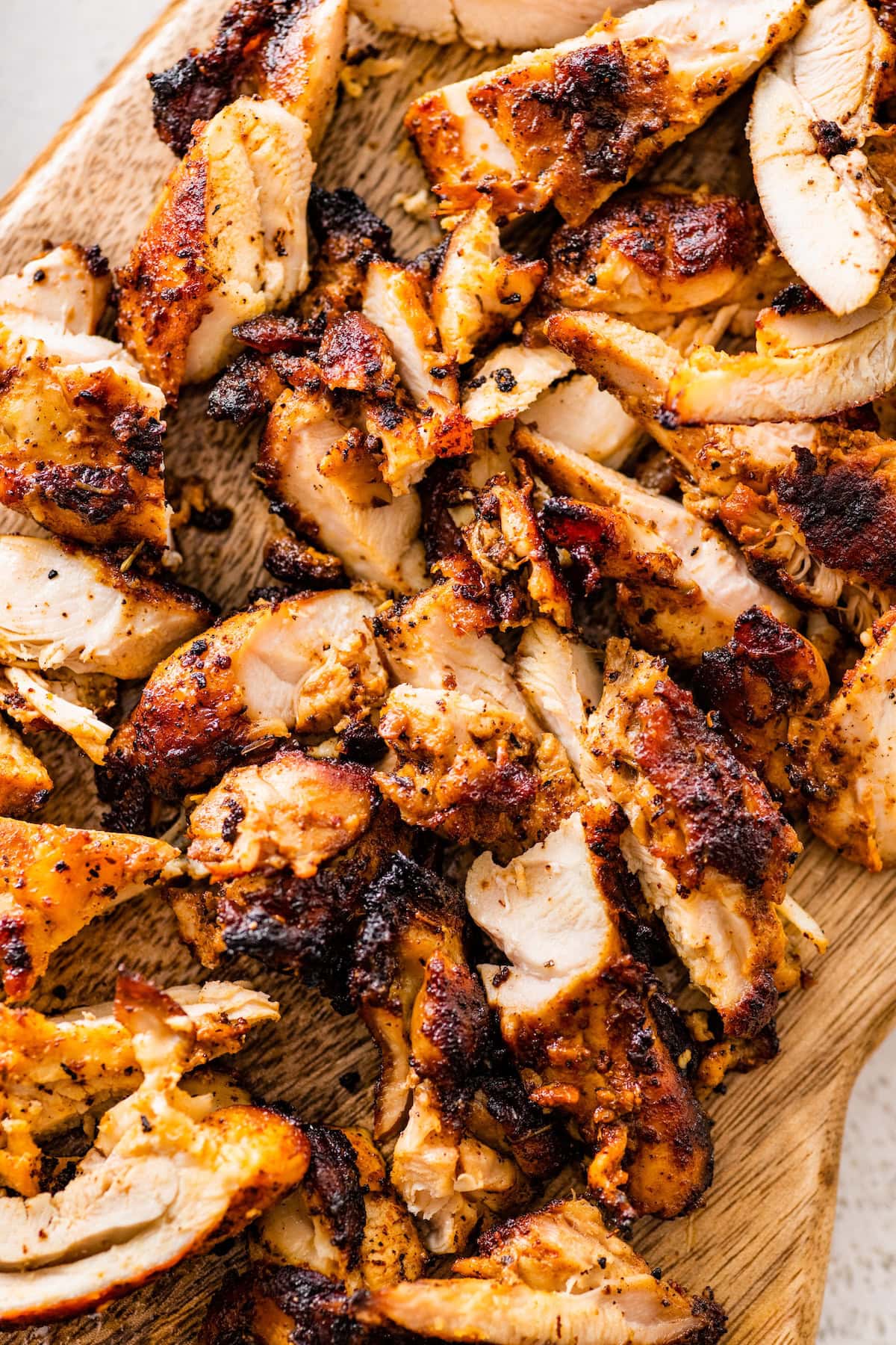 Sliced chipotle chicken on a wooden cutting board.